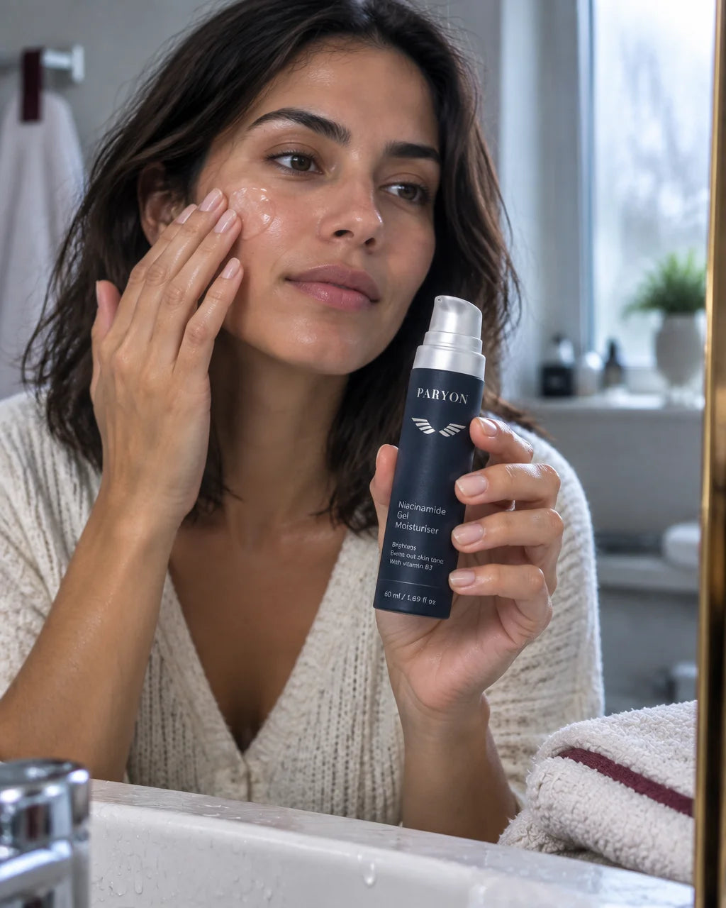 PARYON Niacinamide Gel Moisturiser bottle, exact from ref r02, held close and sharp by a woman with