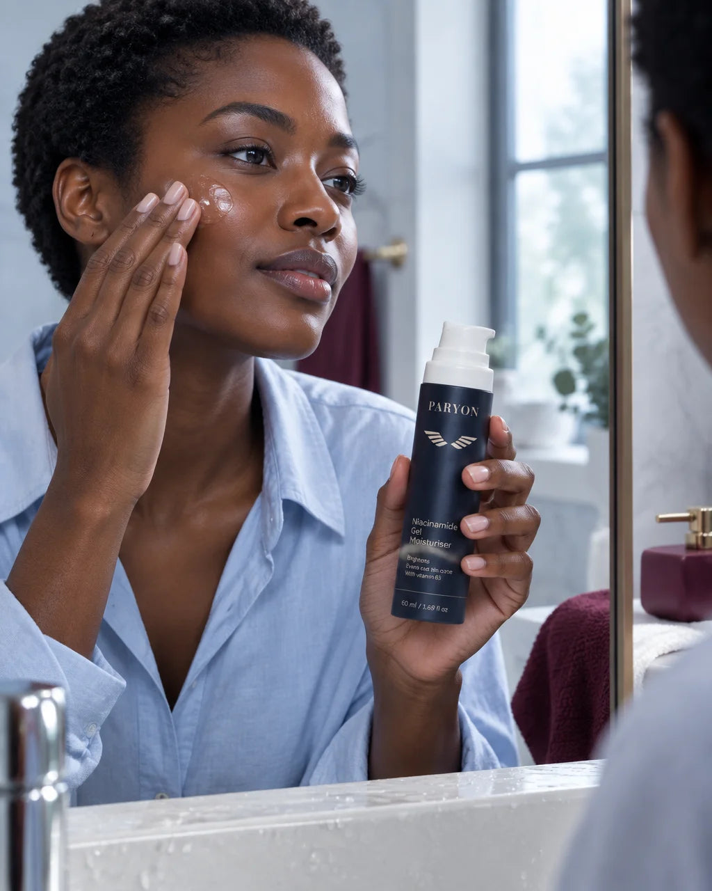 PARYON Niacinamide Gel Moisturiser bottle, exact from ref r02, held large and sharp by a woman with